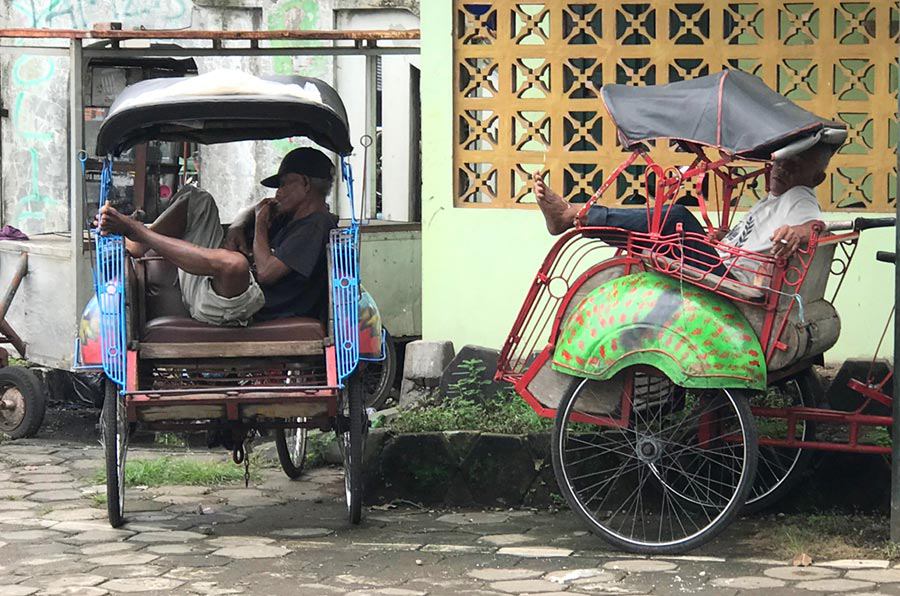 Becak drivers resting in their bike cabs